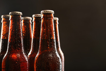 Glazen flessen bier op donkere achtergrond