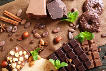 Chocolate with mint, spices and coffee beans on table, closeup