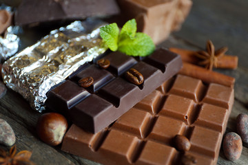 Delicious chocolate with spices on wooden table, closeup