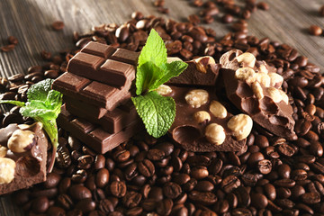 Chocolate with mint and coffee beans on wooden table, closeup