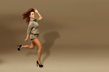 Fashion photo of running brunette woman over brown background