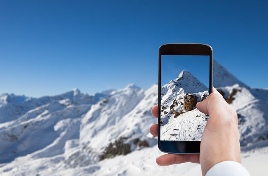 Person Photographing Snowy Mountain Landscape