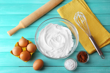 Whipped egg whites for cream on wooden table, top view