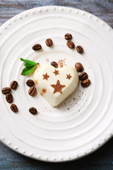Tasty panna cotta dessert on plate, on wooden table