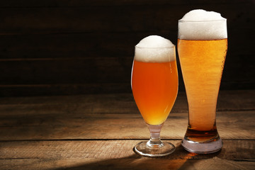 Glasses of beer on wooden background