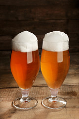 Glasses of beer on wooden background