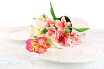 Table setting with flowers, isolated on white