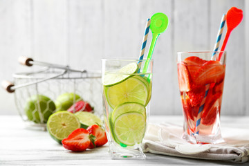 Cocktails with fresh strawberries and lemon lime on wooden background