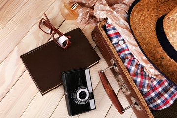 Packing suitcase for trip on wooden background