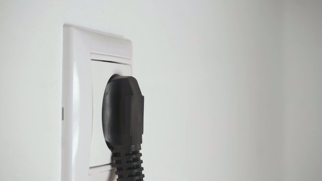 Black plug in a wall socket rapid video