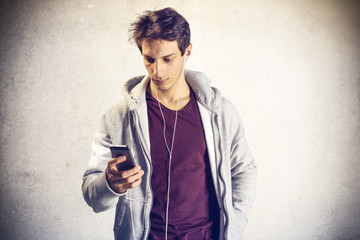Portrait of young boy using mobile phone with headphones