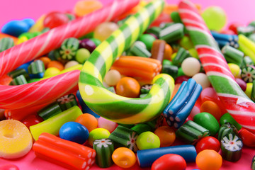 Colorful candies on pink background