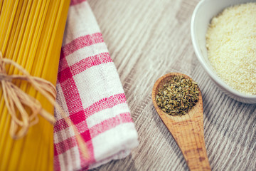 spaghetti and other ingredients, parmesan, oregano on table