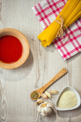 spaghetti and other ingredients, parmesan, oregano on table