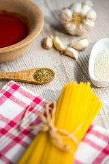 spaghetti and other ingredients, parmesan, oregano on table