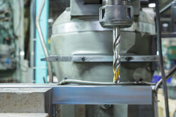 Old industrial drill working in metal workshop