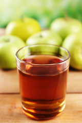 Glass of healthy fresh juice of apples on wooden background