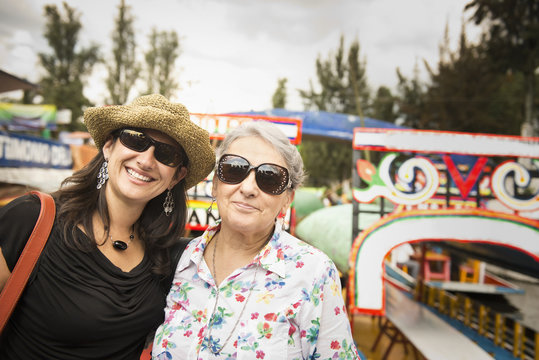 Hispanic Women Smiling At Amusement Park