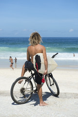 Fototapeta na wymiar Brazilian Surfer on Bike Ipanema Beach Rio Brazil