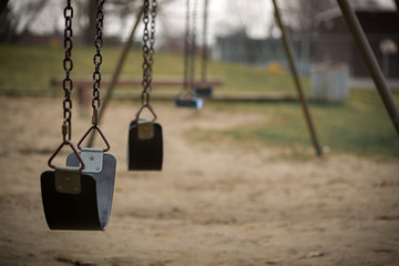 Empty Swings at Playground on Dull Day
