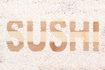 Rice grain. Word sushi written on wooden cutting board