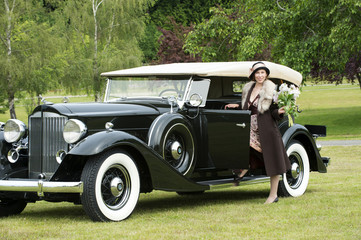 Caucasian woman by vintage car