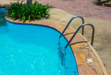 Grab bars ladder in blue swimming pool