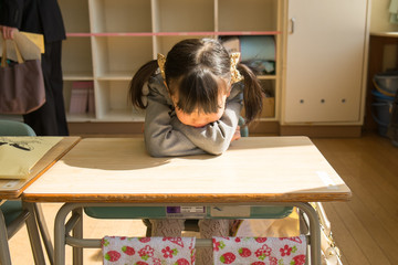 机に座る小学生