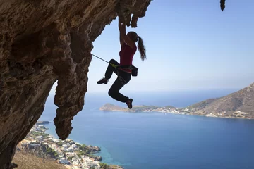 Rolgordijnen Female rock climber struggling on challenging route on cliff  © Andrey Bandurenko