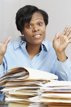 African businesswoman behind stacks of folders