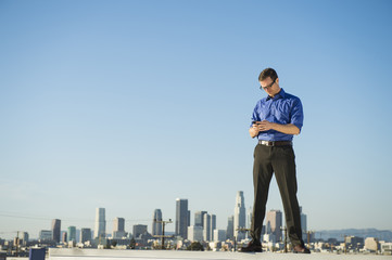 Caucasian businessman standing on urban rooftop