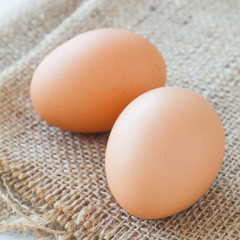 Healthy food brown chicken egg on brown fabric background