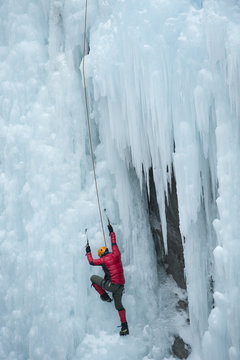 Caucasian man climbing ice wall
