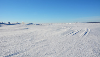 Obraz premium Frozen sea landscape at sunny day with sky tracks