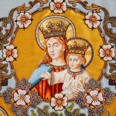 Old embroidered religious icon with Virgin Mary holding Jesus