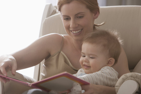 Caucasian mother reading book to son