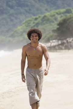 Hispanic man walking on beach