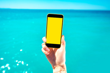Holding phone on the sea background