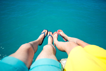 Couple's legs in slippers on the sea background