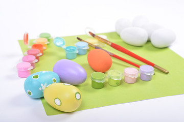 Paintbrushes and paints for coloring wooden eggs