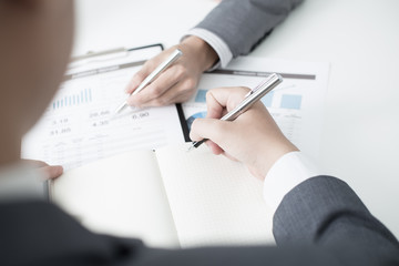 Two businessmen looking at report and having a discussion in off