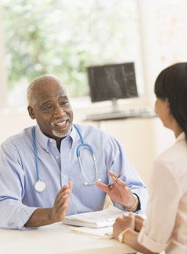 Black doctor and patient talking in office