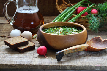 Okroshka with kvass in a wooden bowl and a wooden spoon