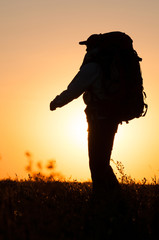 Hiker with backpack walking in the field