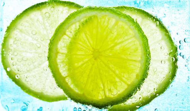 Cut limes in the water with bubbles