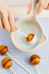 Decorating cake pops with blue icing