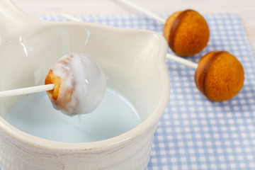 Decorating cake pops with blue icing