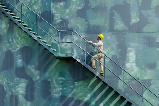 Hispanic worker climbing water tower