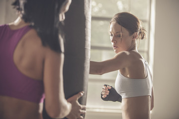 Woman working with trainer in gym