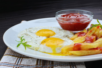 Fried eggs with fries and ketchup